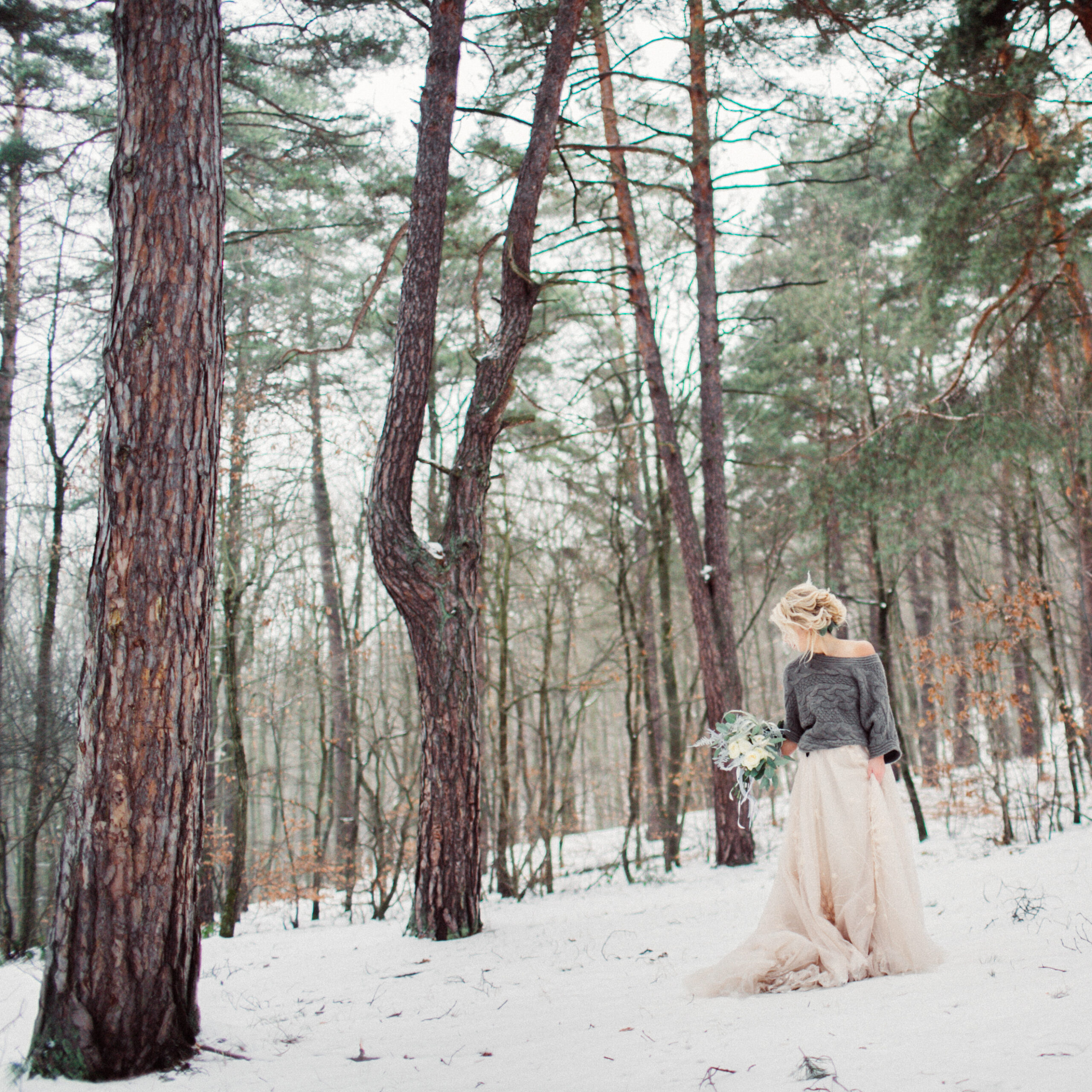 Beautiful stylish bride walking in the winter park